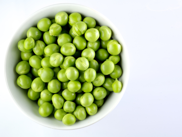 Green peas in the bowl isolated on white background